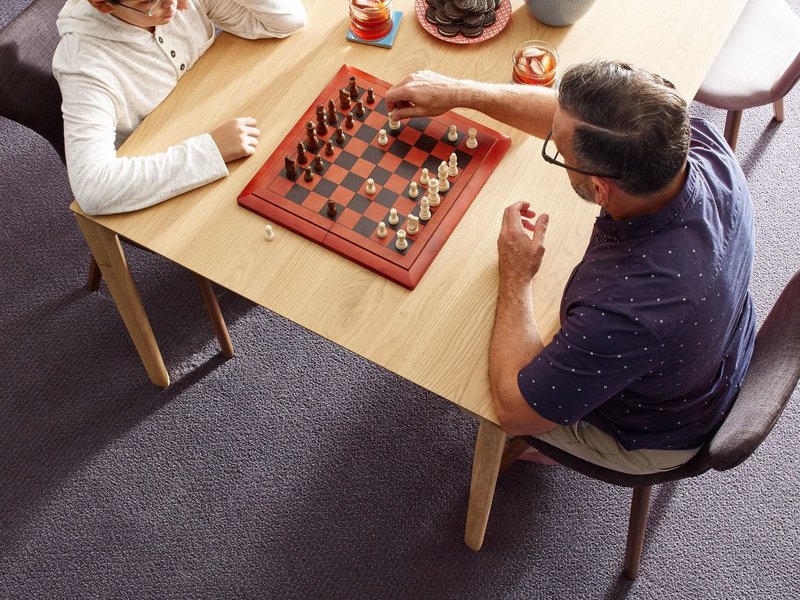 Before Your Floor Arrives: Pair of people playing chess at a table from Farrior's Flooring in Wallace